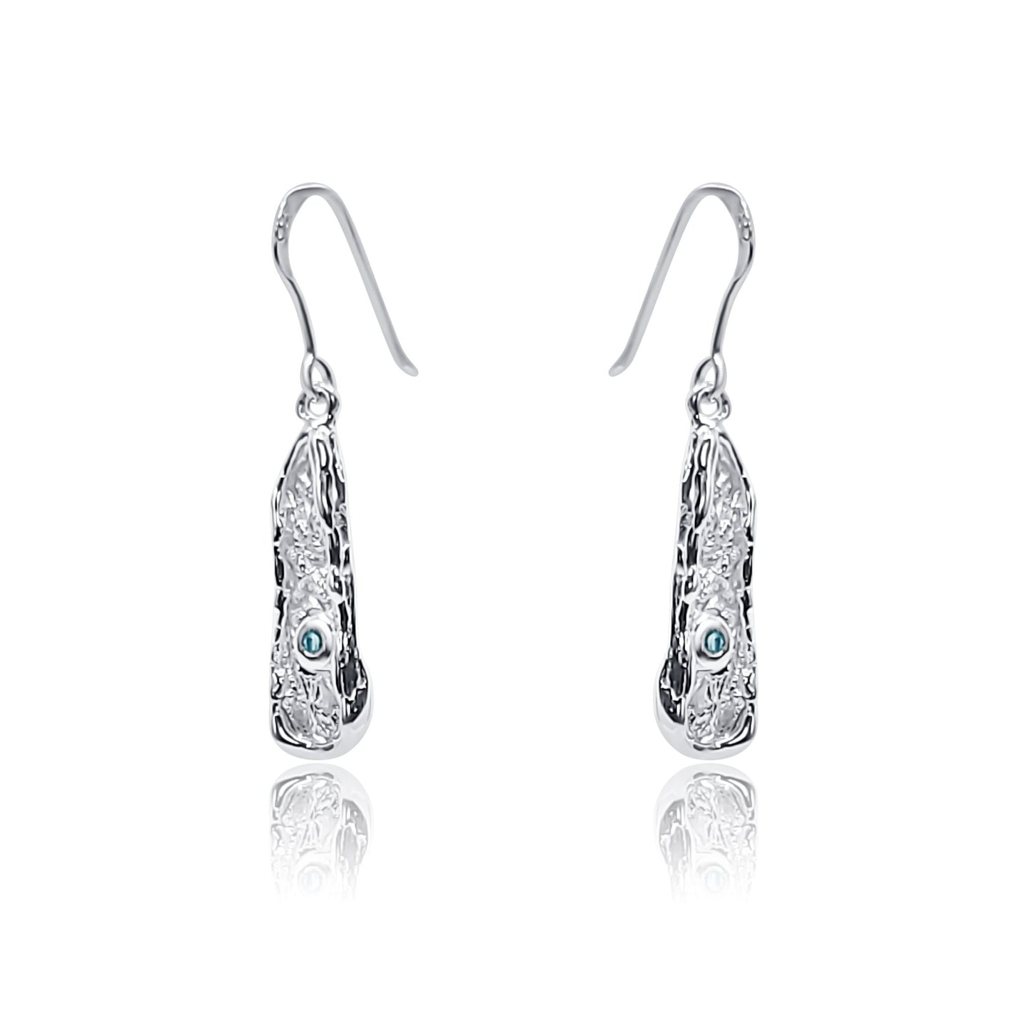 Angled view of one-of-a-kind handcrafted sterling silver dangle earrings with organic texture and natural blue topaz.