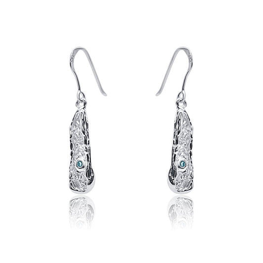 Angled view of one-of-a-kind handcrafted sterling silver dangle earrings with organic texture and natural blue topaz.