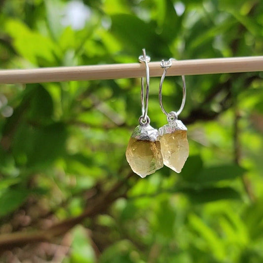 <img src="//www.joiedesigns.ca/cdn/shop/files/citrine-quartz-silver-dangle-hoops-647867.jpg?v=1714795475&width=1946" alt="raw citrine silver dangles on hoop earrings in front of green leaves" srcset="//www.joiedesigns.ca/cdn/shop/files/citrine-quartz-silver-dangle-hoops-647867.jpg?v=1714795475&width=246 246w, //www.joiedesigns.ca/cdn/shop/files/citrine-quartz-silver-dangle-hoops-647867.jpg?v=1714795475&width=493 493w, //www.joiedesigns.ca/cdn/shop/files/citrine-quartz-silver-dangle-hoops-647867.