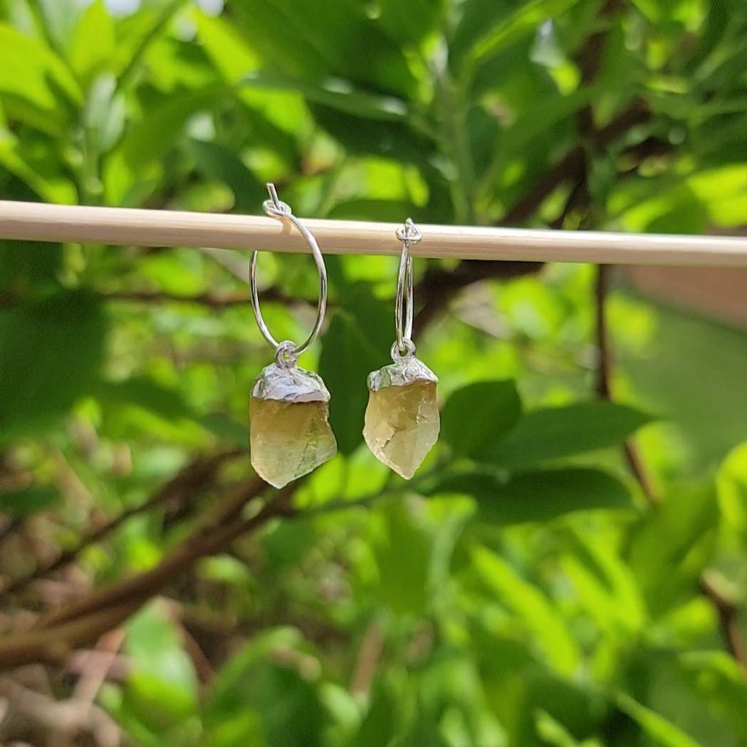 <img src="//www.joiedesigns.ca/cdn/shop/files/citrine-quartz-silver-dangle-hoops-730978.jpg?v=1714795475&width=1946" alt="variegated raw natural citrine dangle hoop earrings" srcset="//www.joiedesigns.ca/cdn/shop/files/citrine-quartz-silver-dangle-hoops-730978.jpg?v=1714795475&width=246 246w, //www.joiedesigns.ca/cdn/shop/files/citrine-quartz-silver-dangle-hoops-730978.jpg?v=1714795475&width=493 493w, //www.joiedesigns.ca/cdn/shop/files/citrine-quartz-silver-dangle-hoops-730978.jpg?v=1714795475&