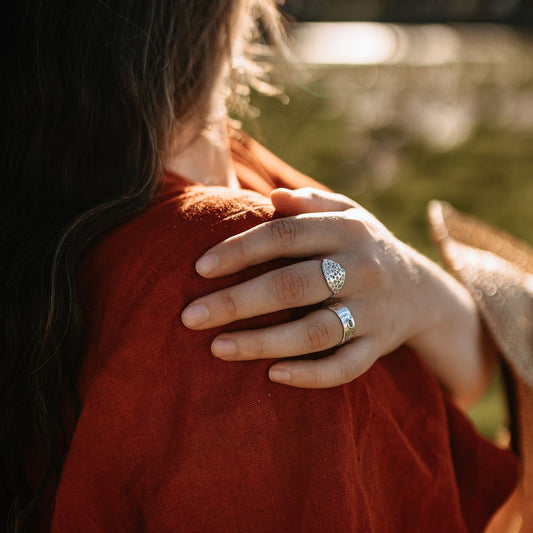 model wearing the silver ring with oval design made from natural weathered seashell texture