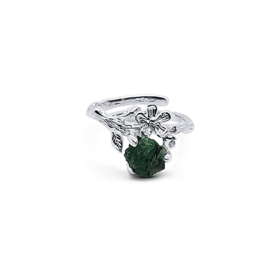 front view of sterling silver flower ring with raw emerald stone in prong setting