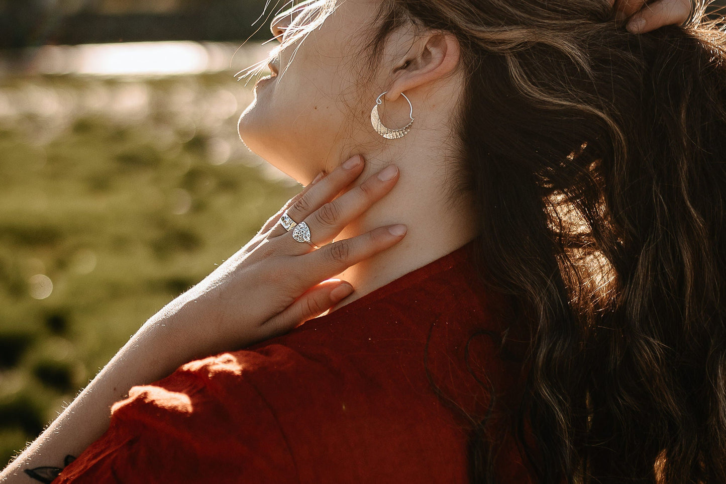 side view- model wearing the seashell textured silver crescent moon hoop earrings