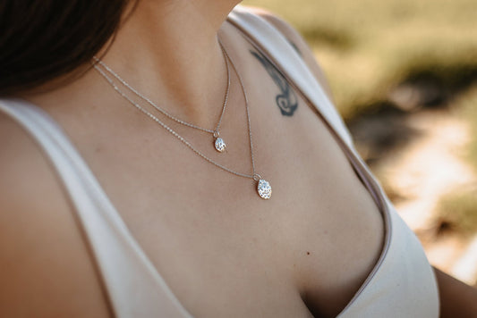 close up of model wearing layered Silver Meri and Meria silver circle pendant necklaces
