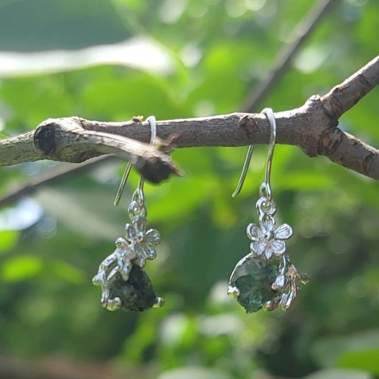 natural raw emerald silver flower earrings hanging from branch