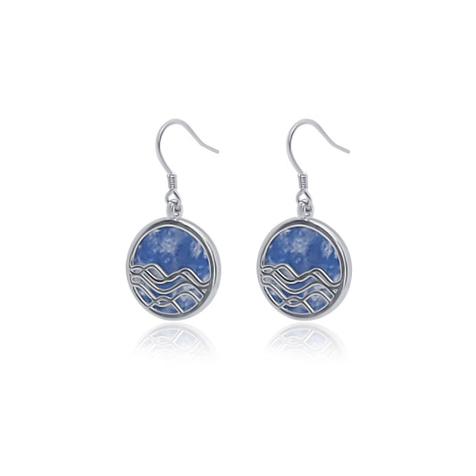 angle view of silver and blue sodalite circle earrings. ocean wave dangle earrings with blue background