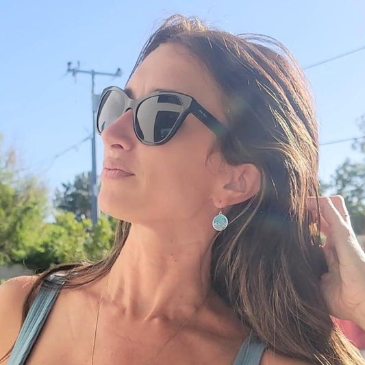 close up of model wearing ocean design turquoise silver circle dangly earrings