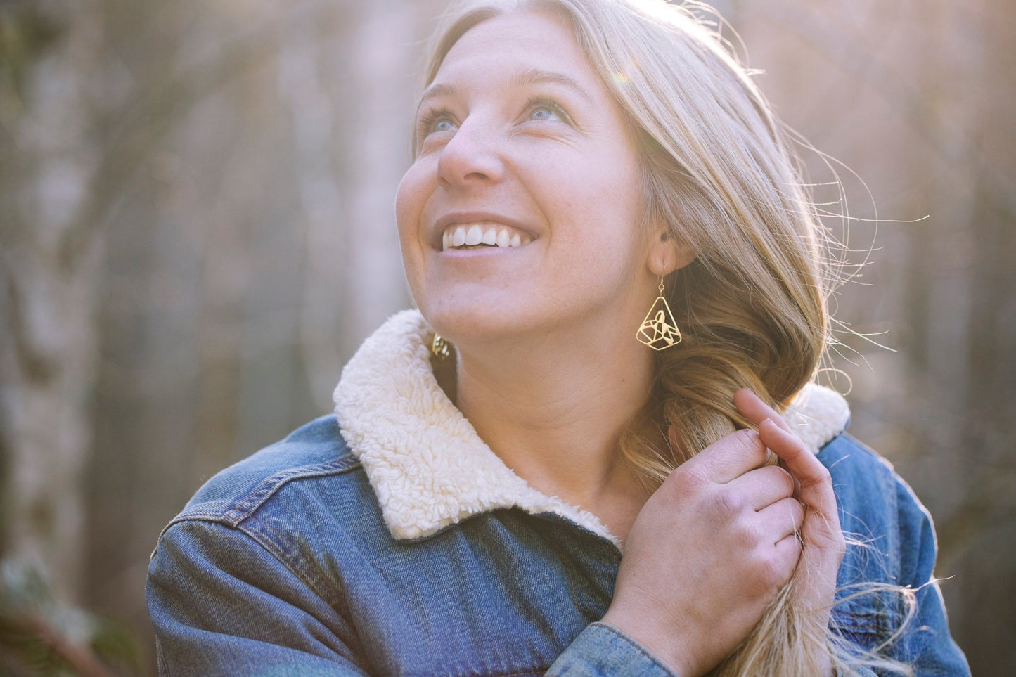 model wearing yellow gold plated black tusk mountain earrings with denim outfit - 1