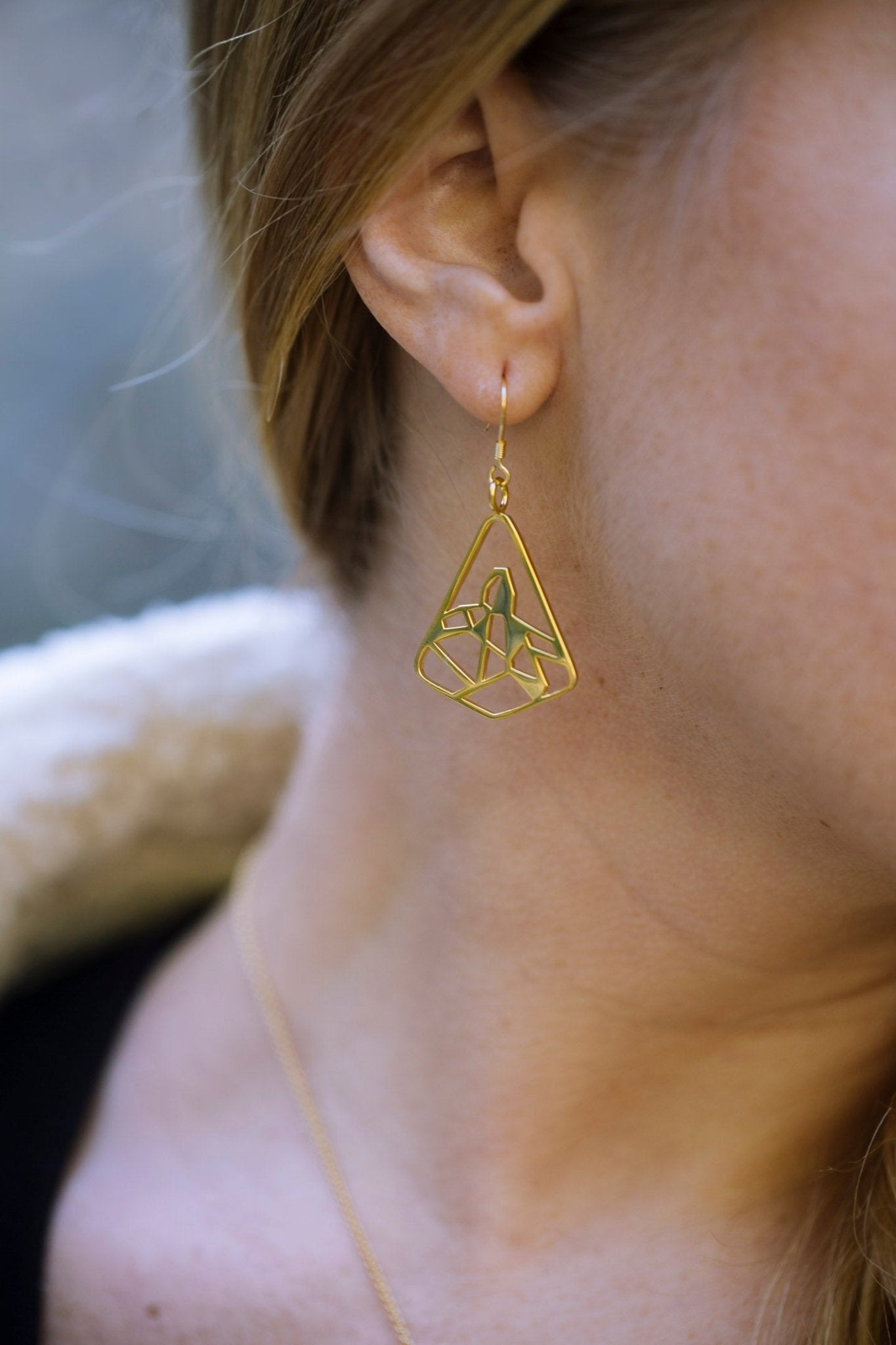 model wearing yellow gold plated black tusk mountain earring closeup - 1