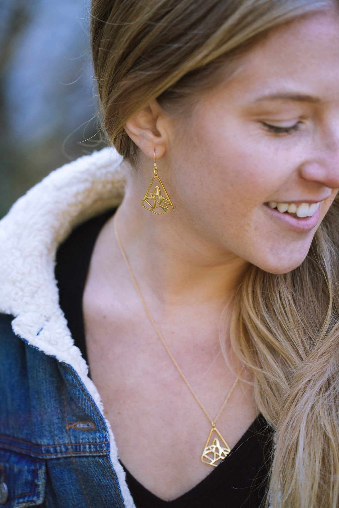 model wearing the gold black tusk earring and necklace