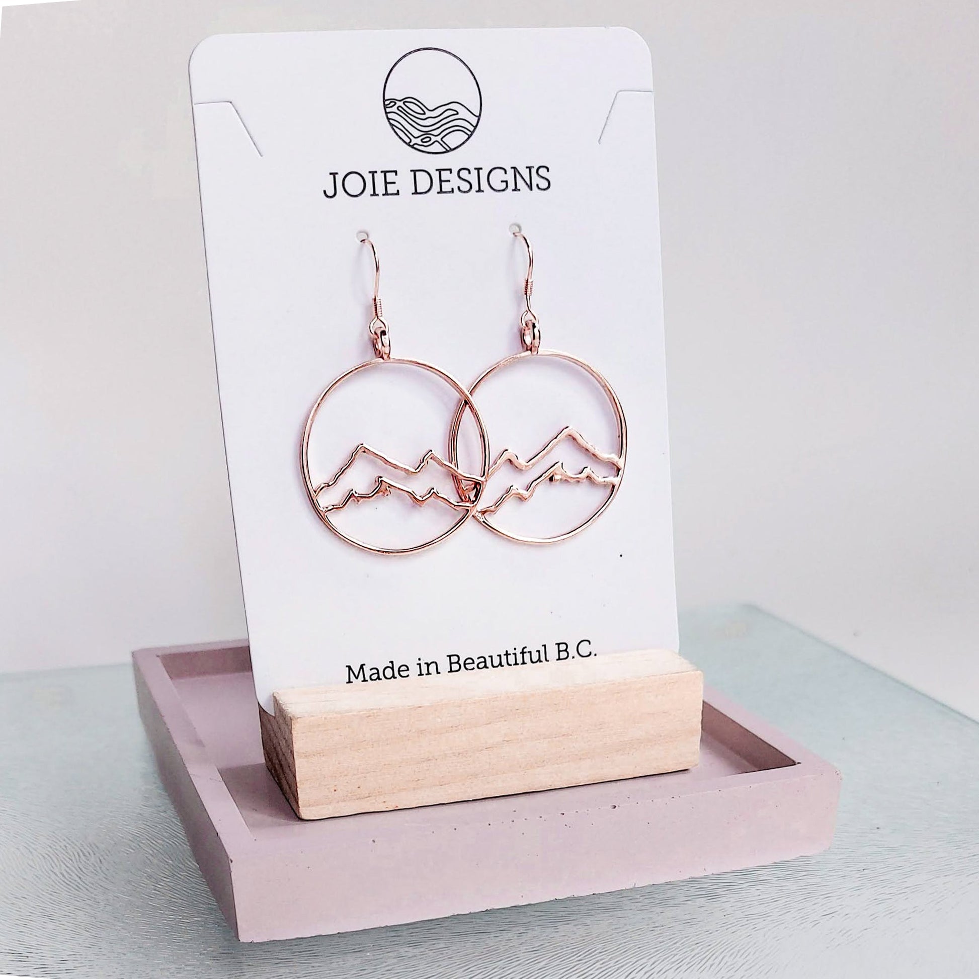 circle earrings, 18k rose gold plated coastal mountain in circle design hook earring showcased on a jewellery card