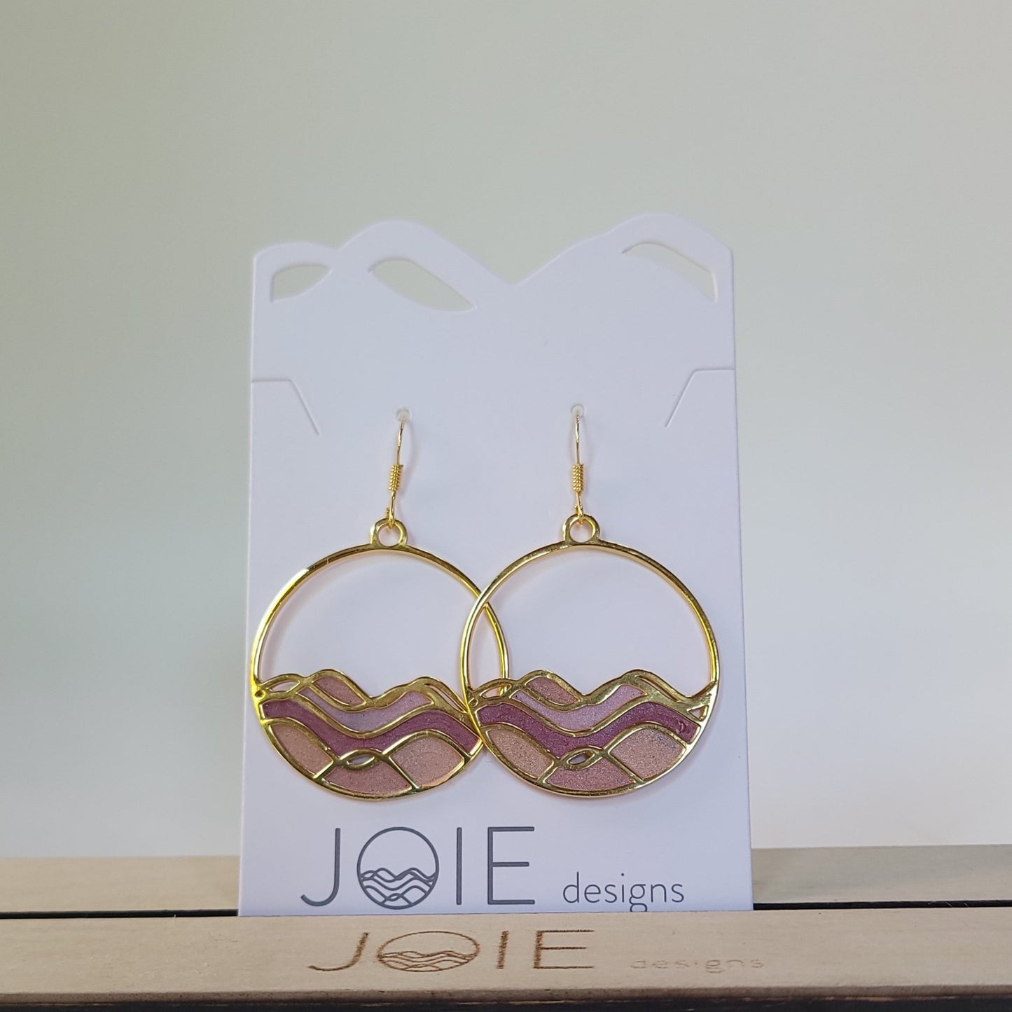 Gold Circle dangle earrings with Golden waves with pink and red resins between the waves creating a stained glass effect 2