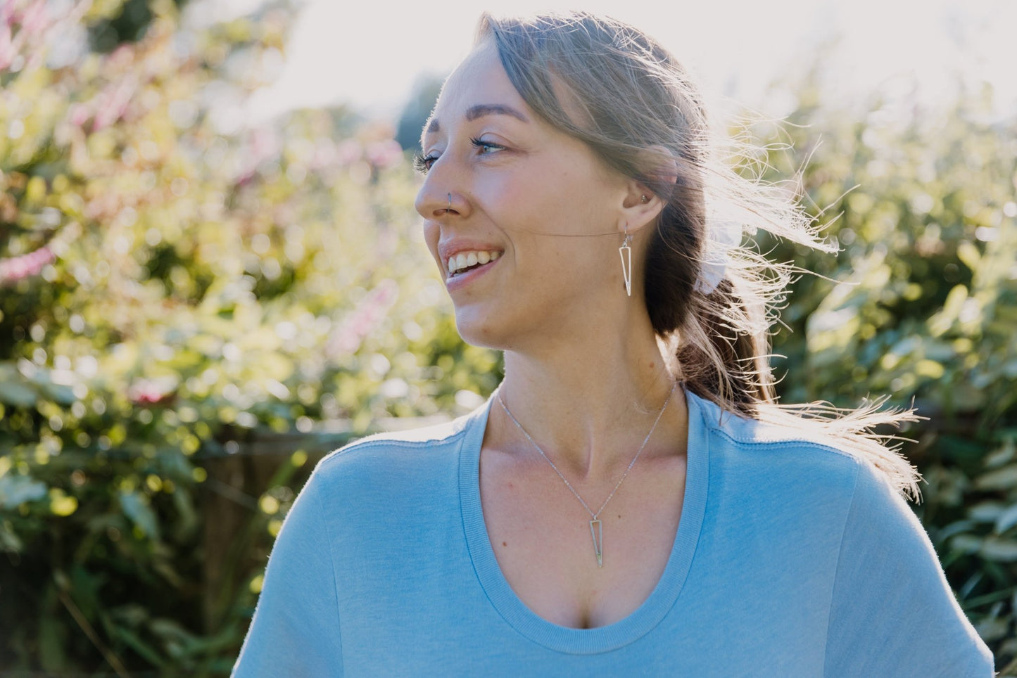 model wearing understated minimalist triangle icicle necklace and drop earrings in silver 2