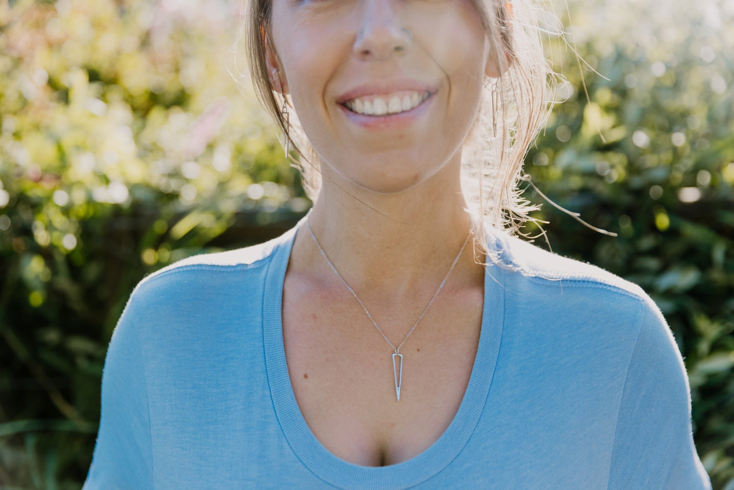 model wearing understated minimalist triangle icicle necklace and icicle drop earrings
