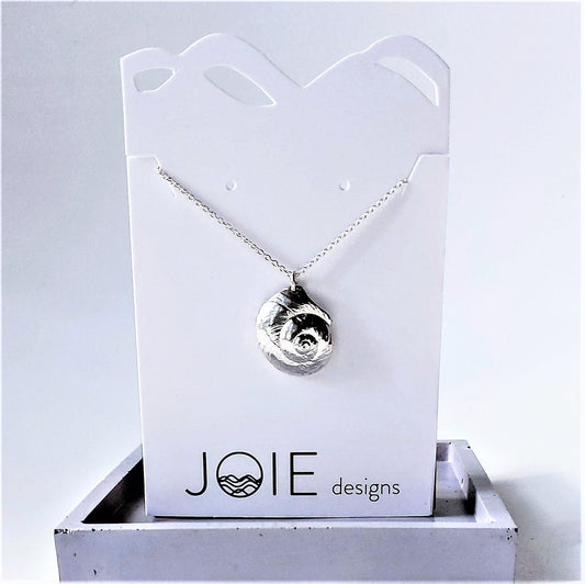 Sterling Silver Luna moon snail seashell necklace on a white jewelry card, ocean jewelry