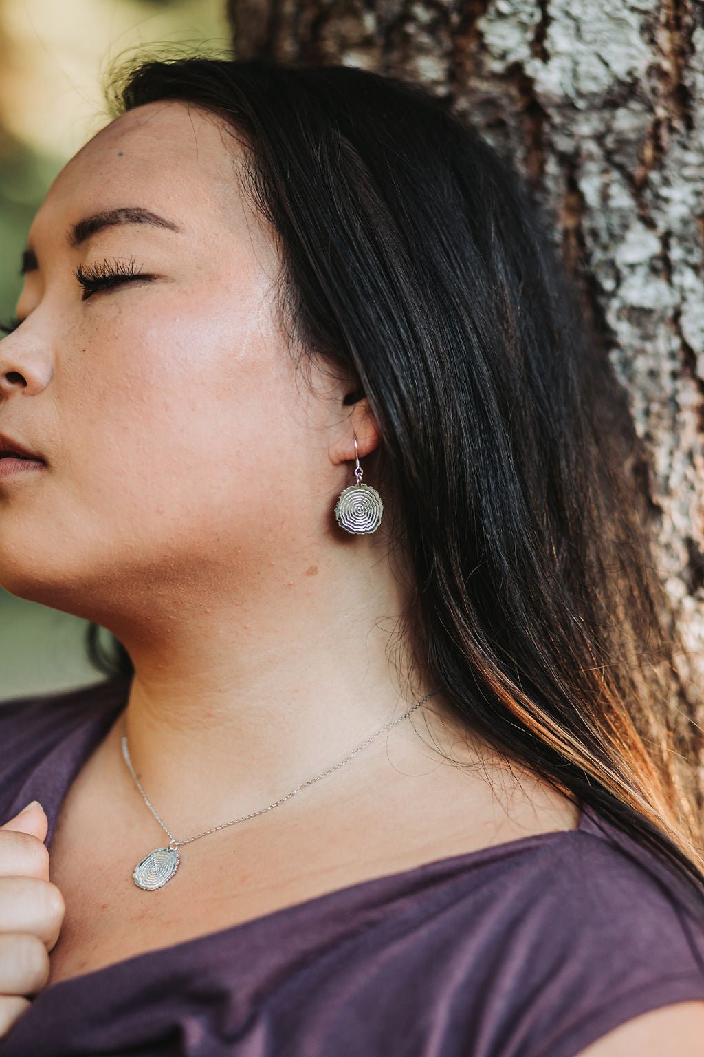 model wearing sterling silver Matsuyo tree ring earrings and necklace
