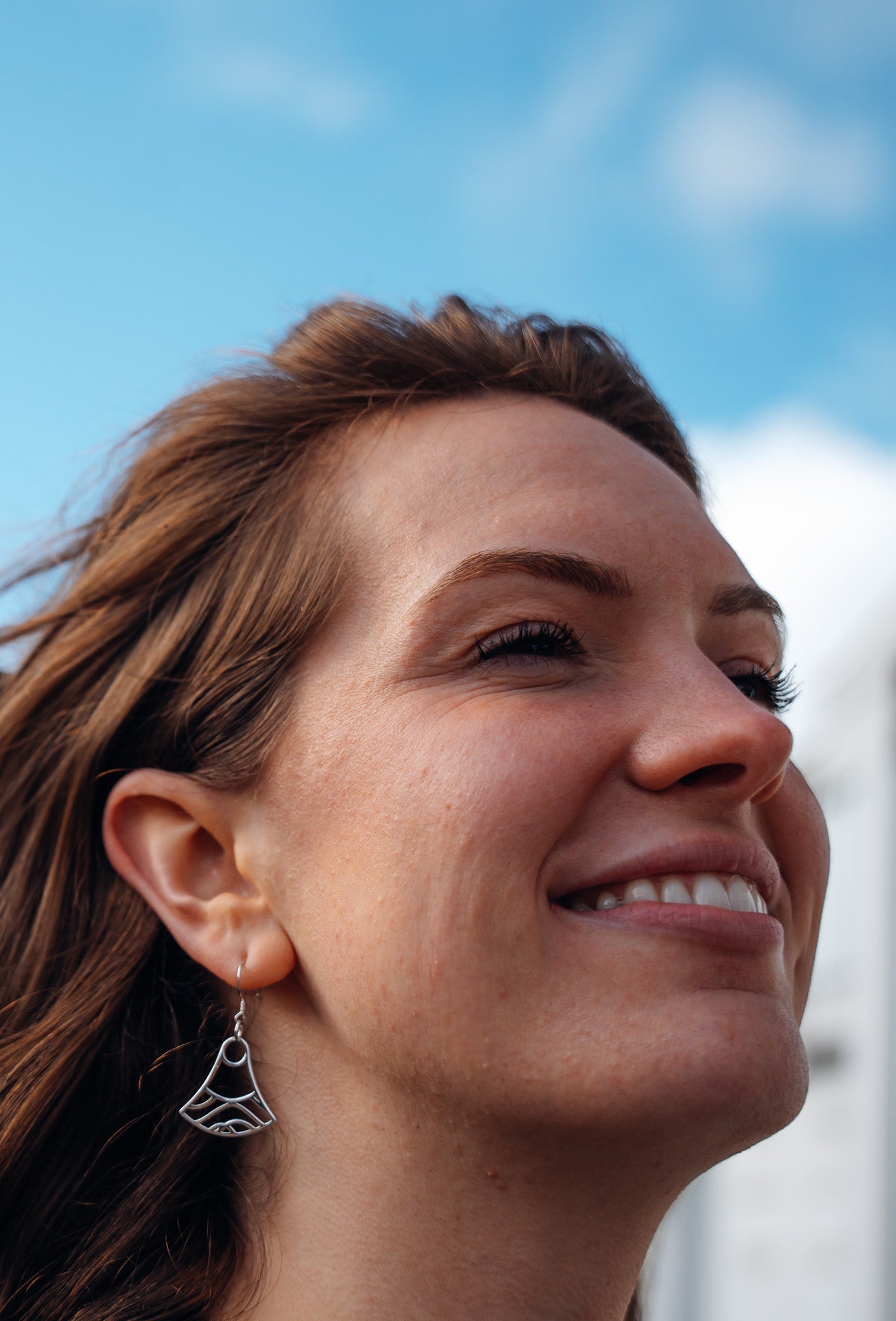 close up of model wearing sterling silver Mei double wave design earrings