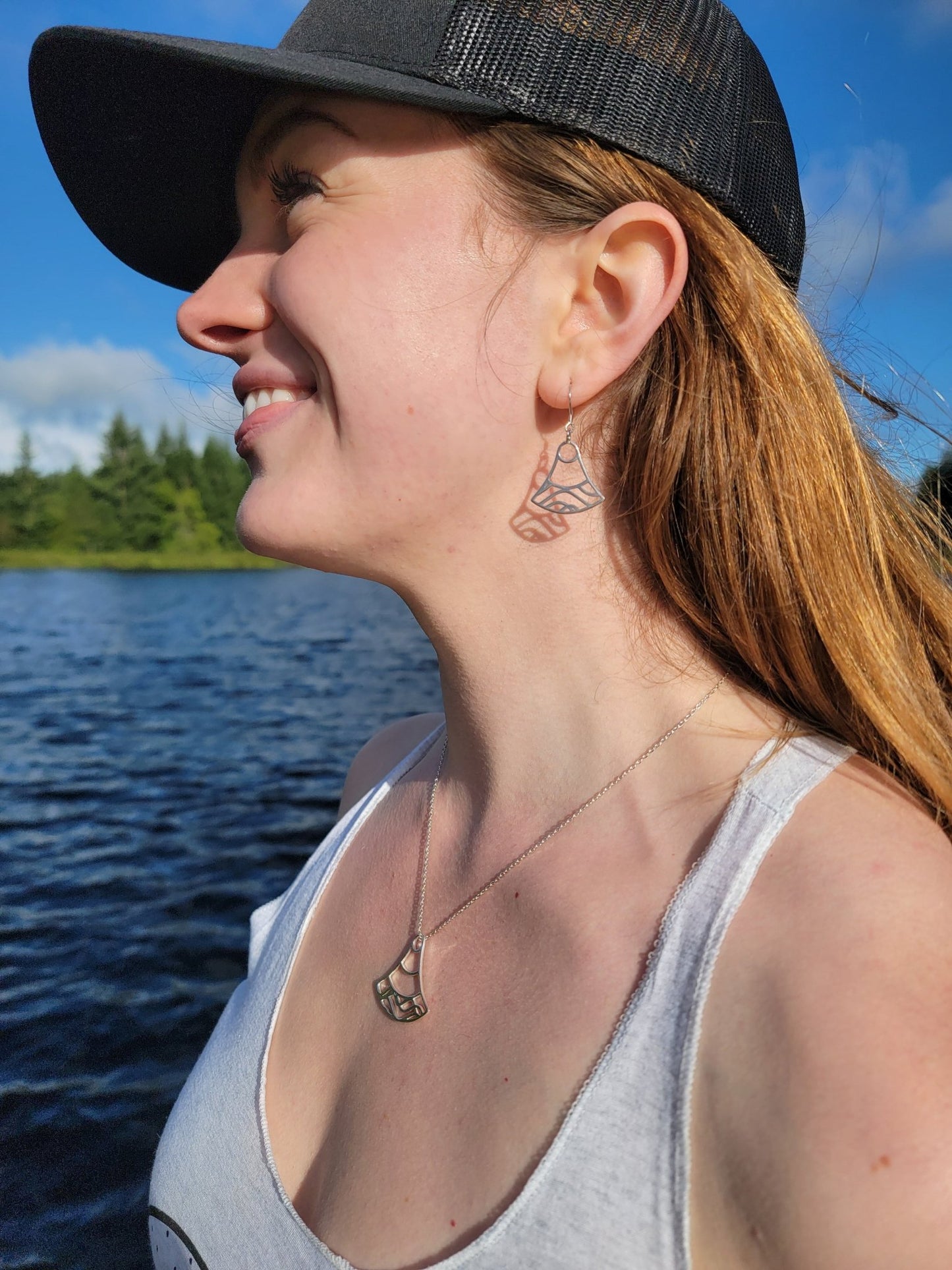 model at lake wearing sterling silver double wave ocean necklace and earrings