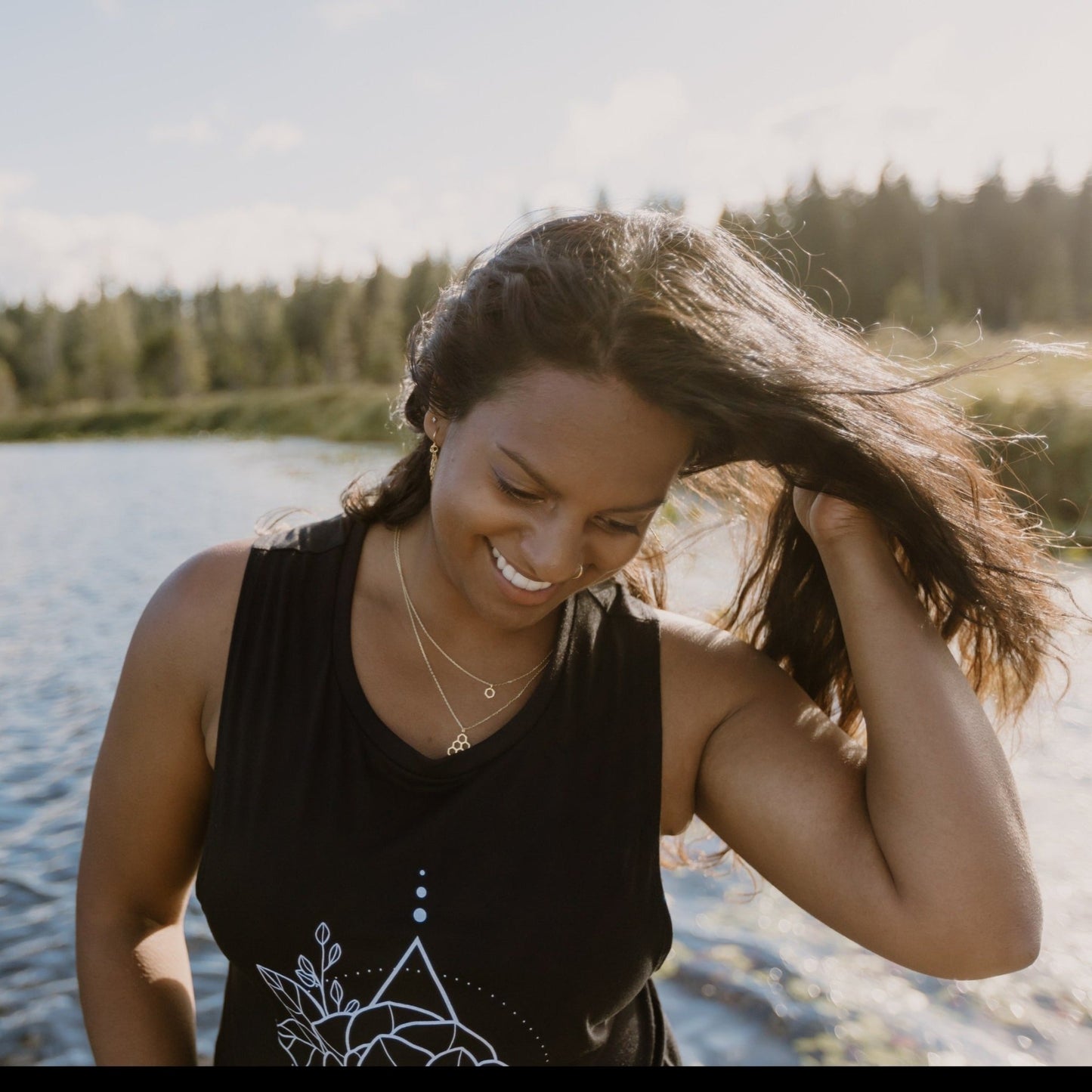 happy model wearing layered gold honeycomb necklaces