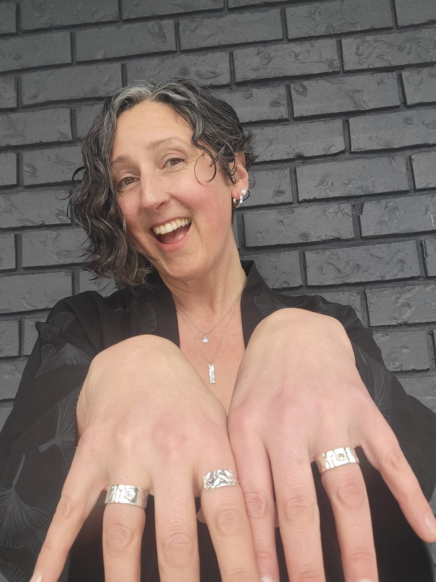 model wearing Nerissa and Marley driftwood textured rings in sterling silver with peridot and white topaz gemstones
