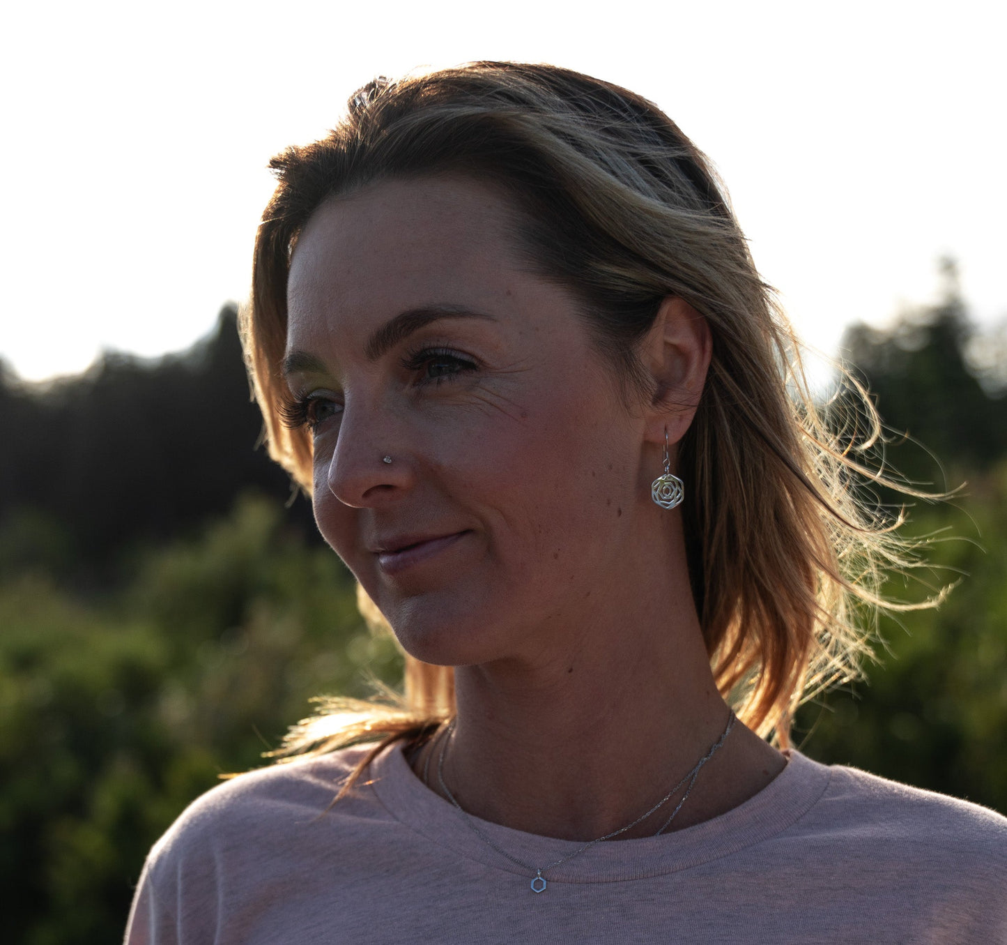 model wearing modern minimalist rose flower dangle earrings in silver