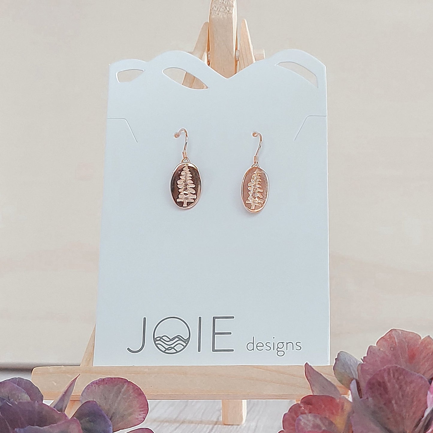 18k rose gold plated Sitka Tree Oval Dangle showcased on a jewelry card
