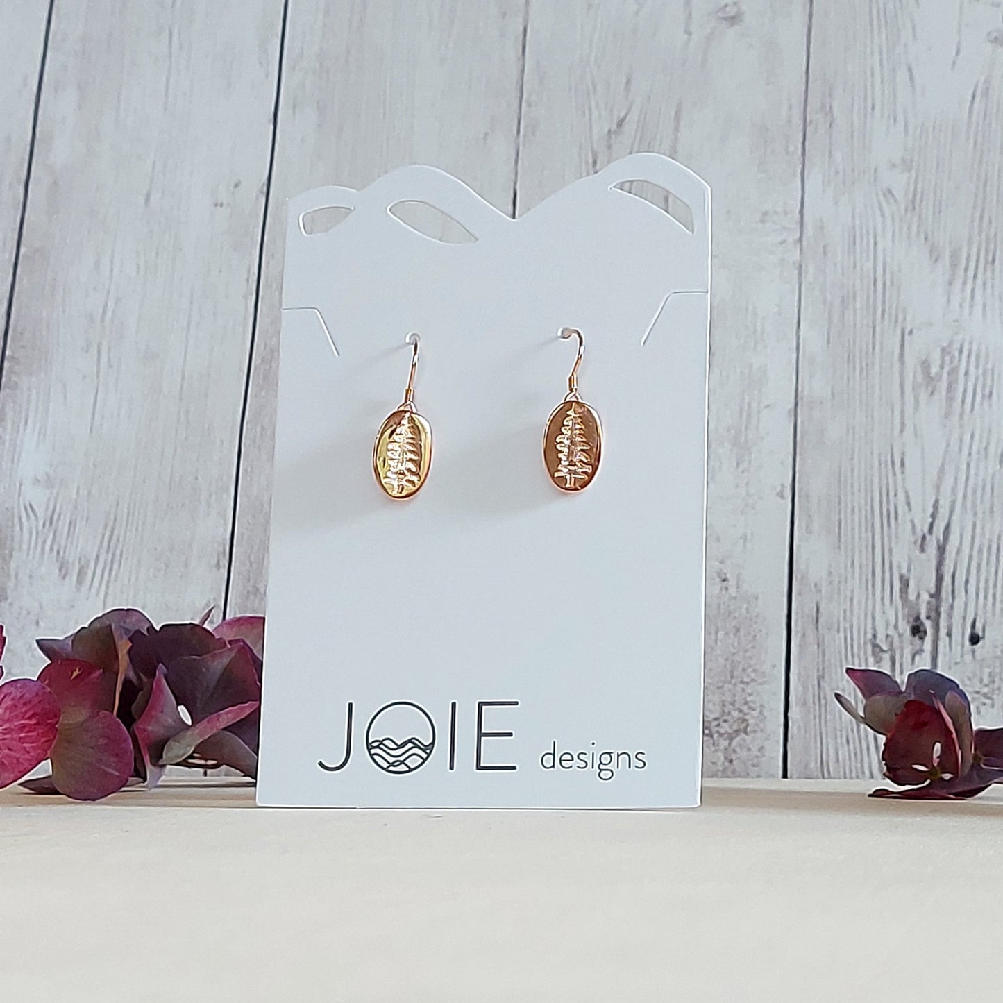 18k yellow gold plated Sitka Tree Oval Dangle showcased on a white jewelry card