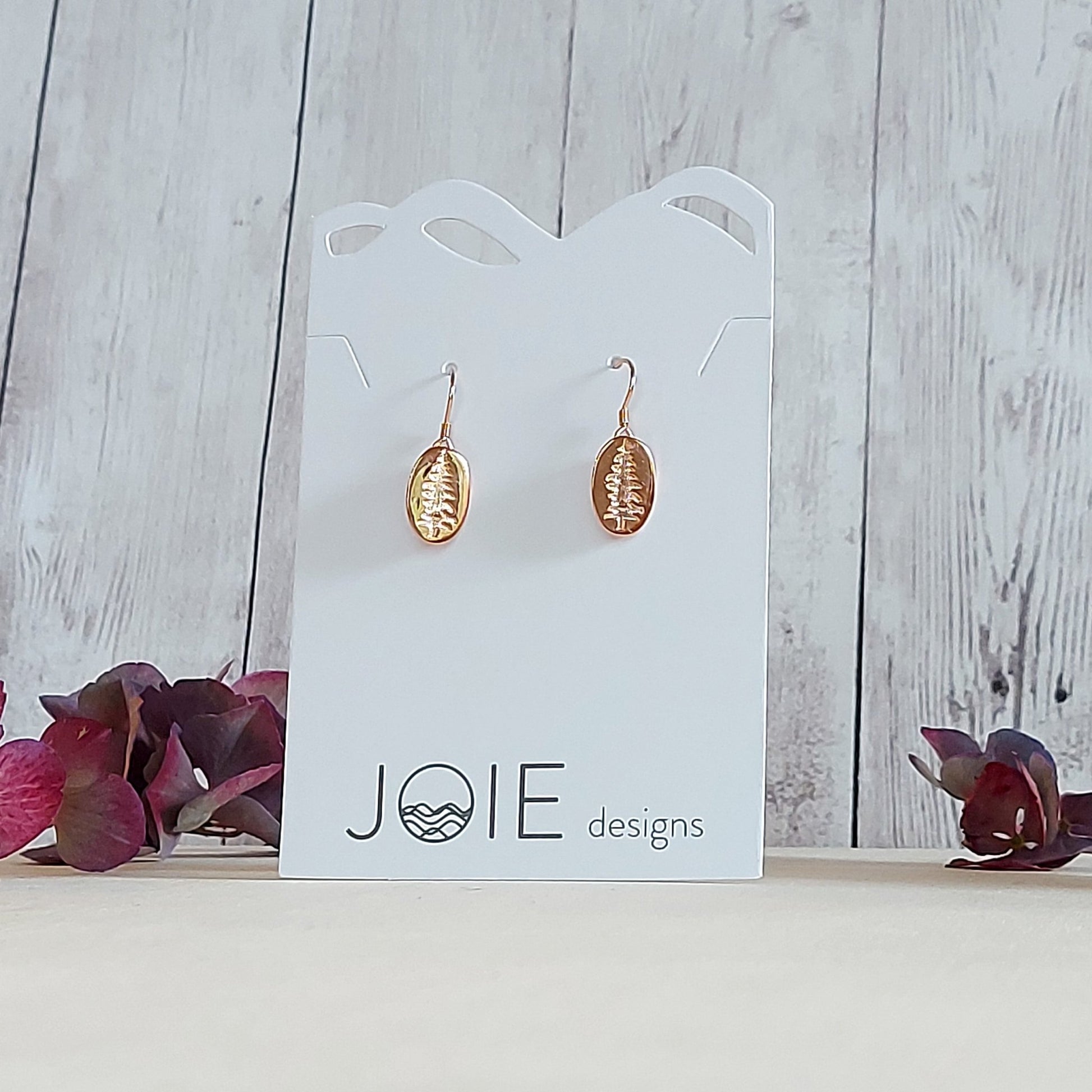 18k yellow gold plated Sitka Tree Oval Dangle showcased on a white jewelry card