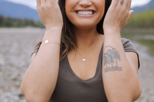 model wearing rose gold plated Sol Sun Inspired Small Circle Necklace with nature background