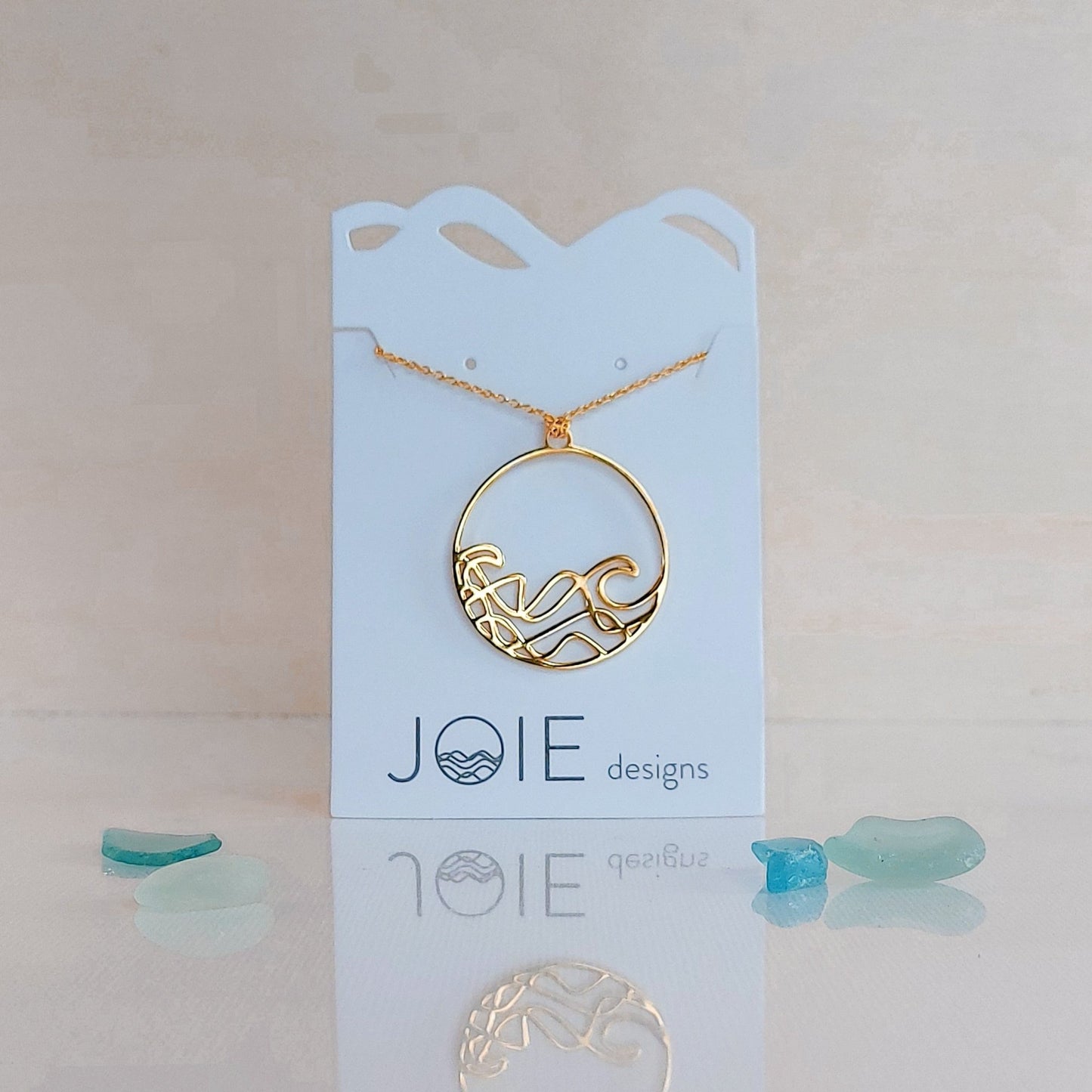 18k plated yellow gold Sombrio beach round wave necklace. surf wave pendant on chain necklace.
