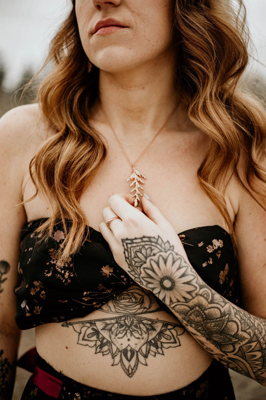 model wearing Nature-inspired cedar leaf necklace in 18k rose gold plating