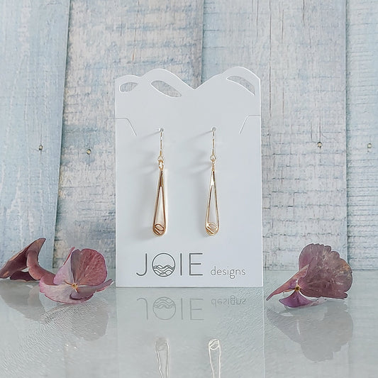 gold elegant water rain drop earrings with blue wood background and pink flowers