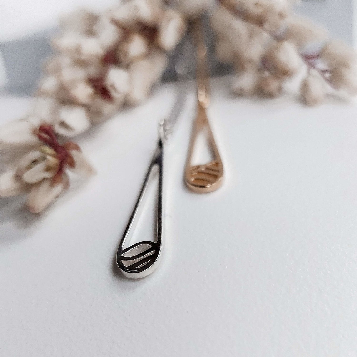 Pair of rain and water drop necklaces in silver and rose gold with flowers