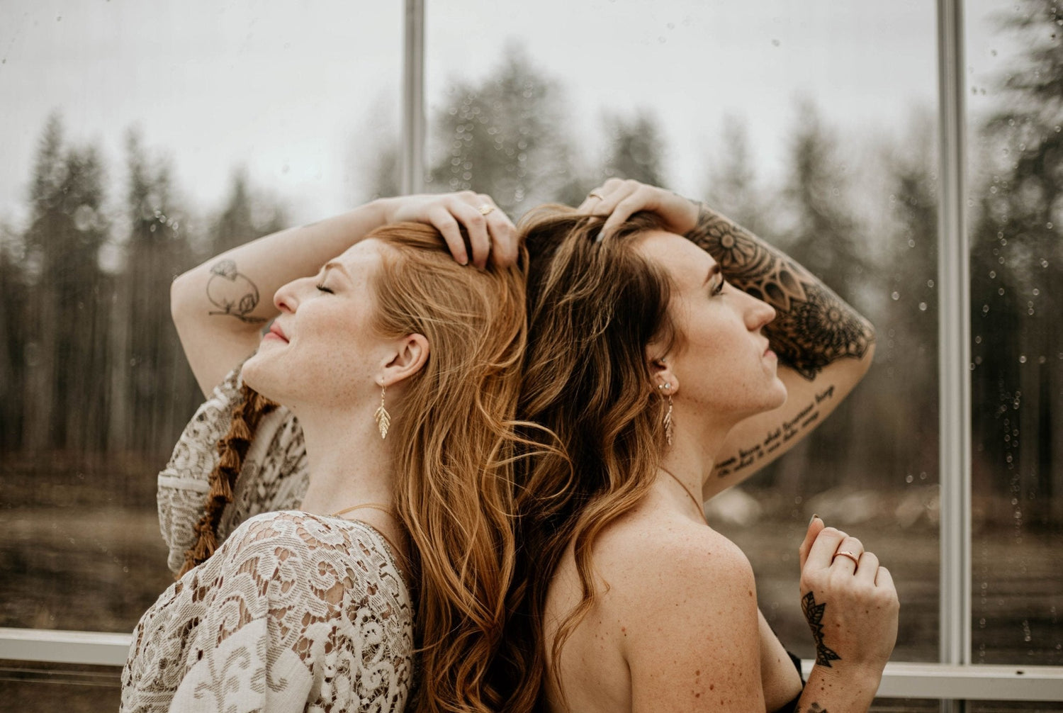 Models wearing cedar leaf earrings with forest and rain background