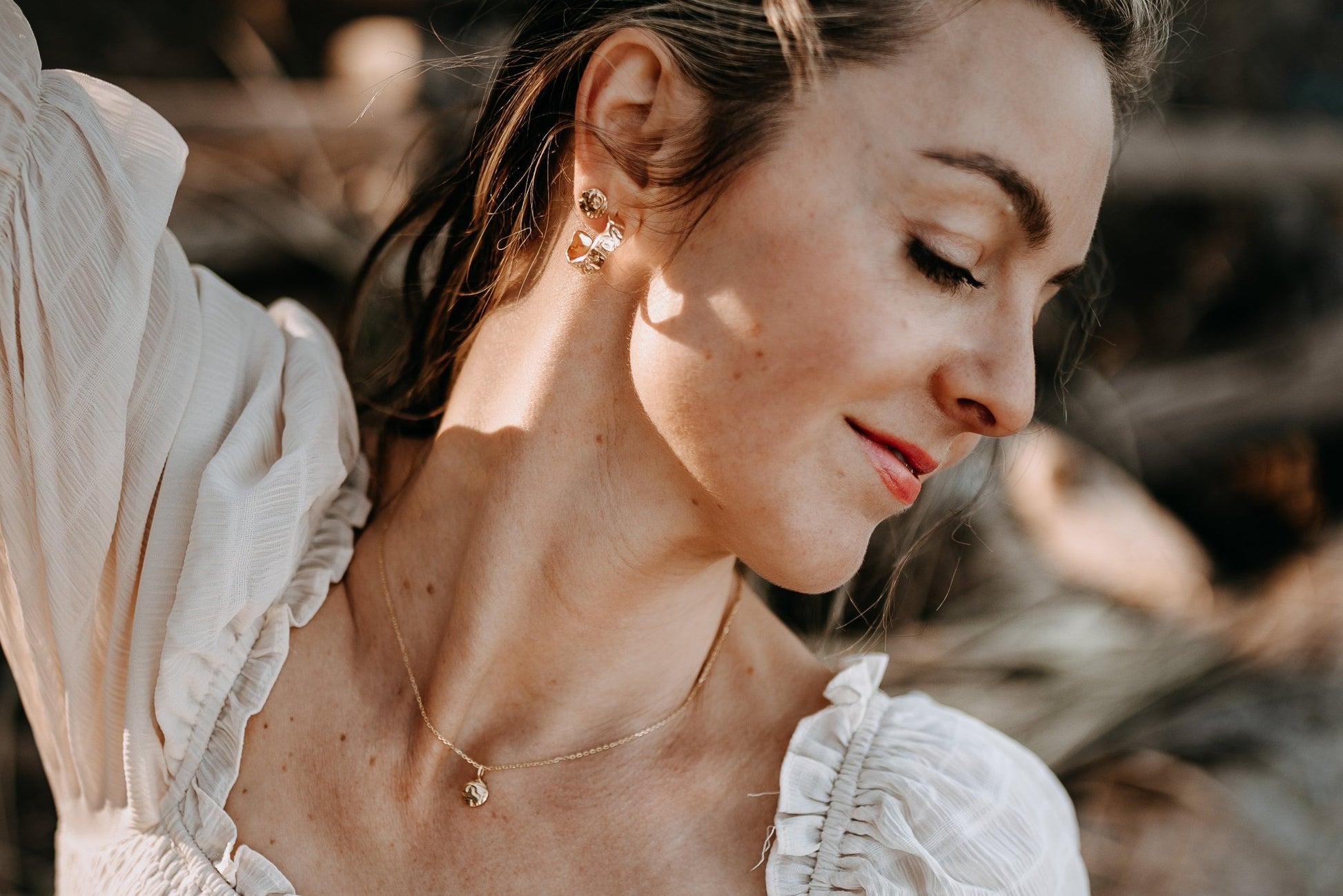 model wearing gold vermeil driftwood textured jewelry and soft beige dress with boho style