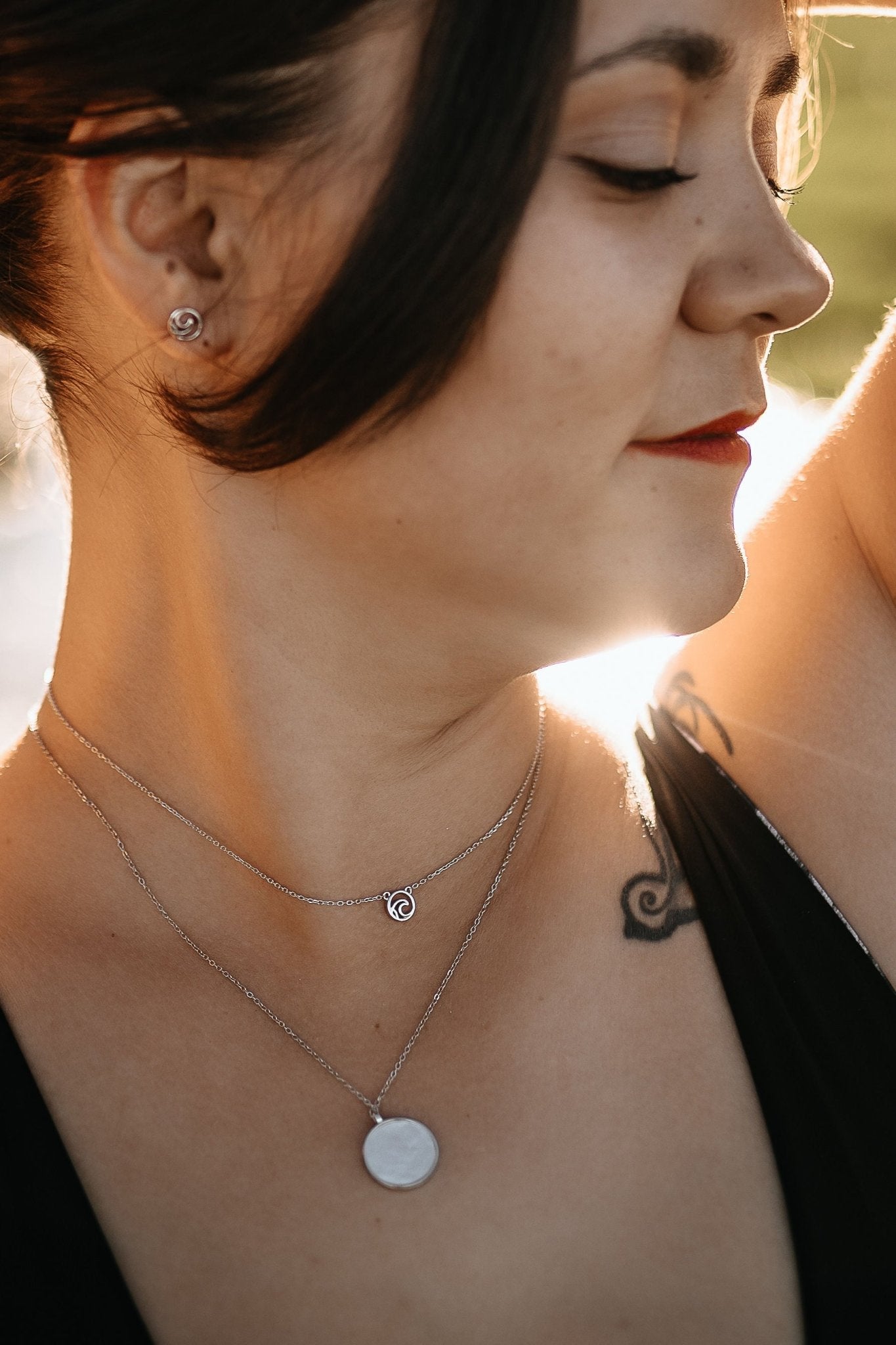 model wearing reversible mother of pearl sterling silver circle necklace showing pearl side.