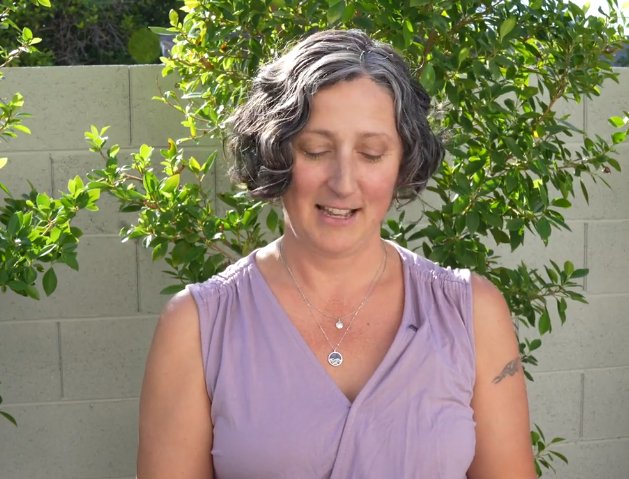 facing view - model wearing the silver and blue sodalite ocean wave circle pendant reversible necklace