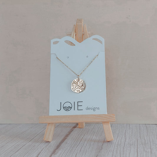 18k plated rose gold  plated tree cross section that resembles a spiderweb