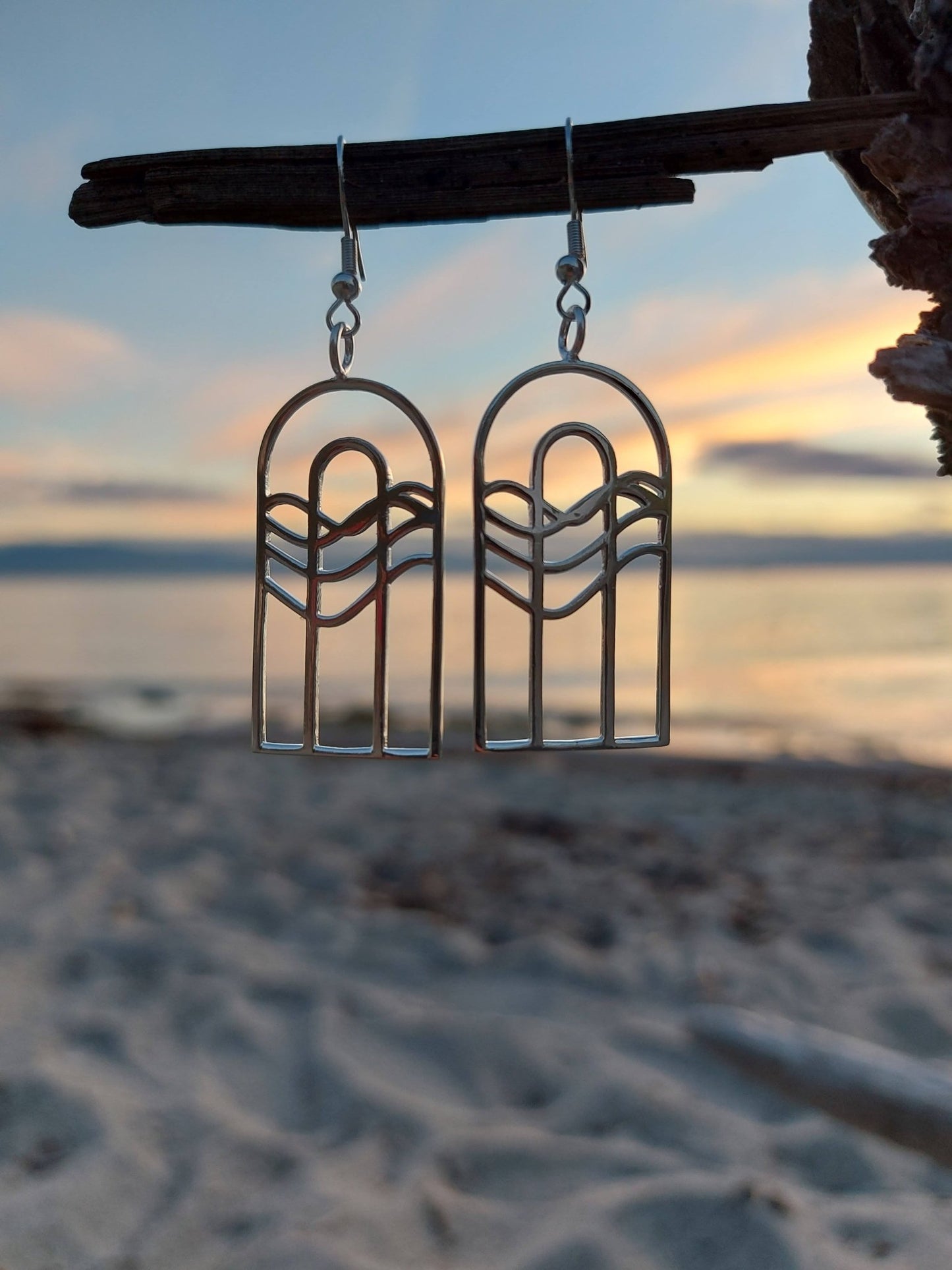 sterling silver earrings composed of two concentric arches with water pattern going across just above the centre