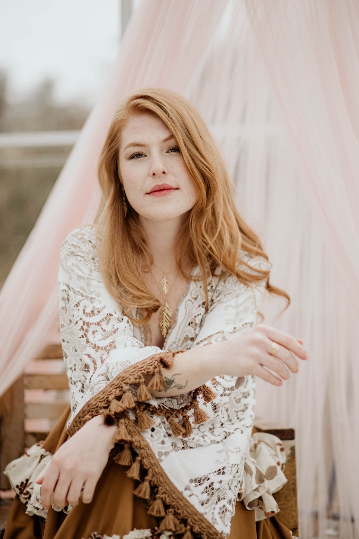 18k plated yellow gold cedar necklace on model wearing lace dress under a pink mesh canopy