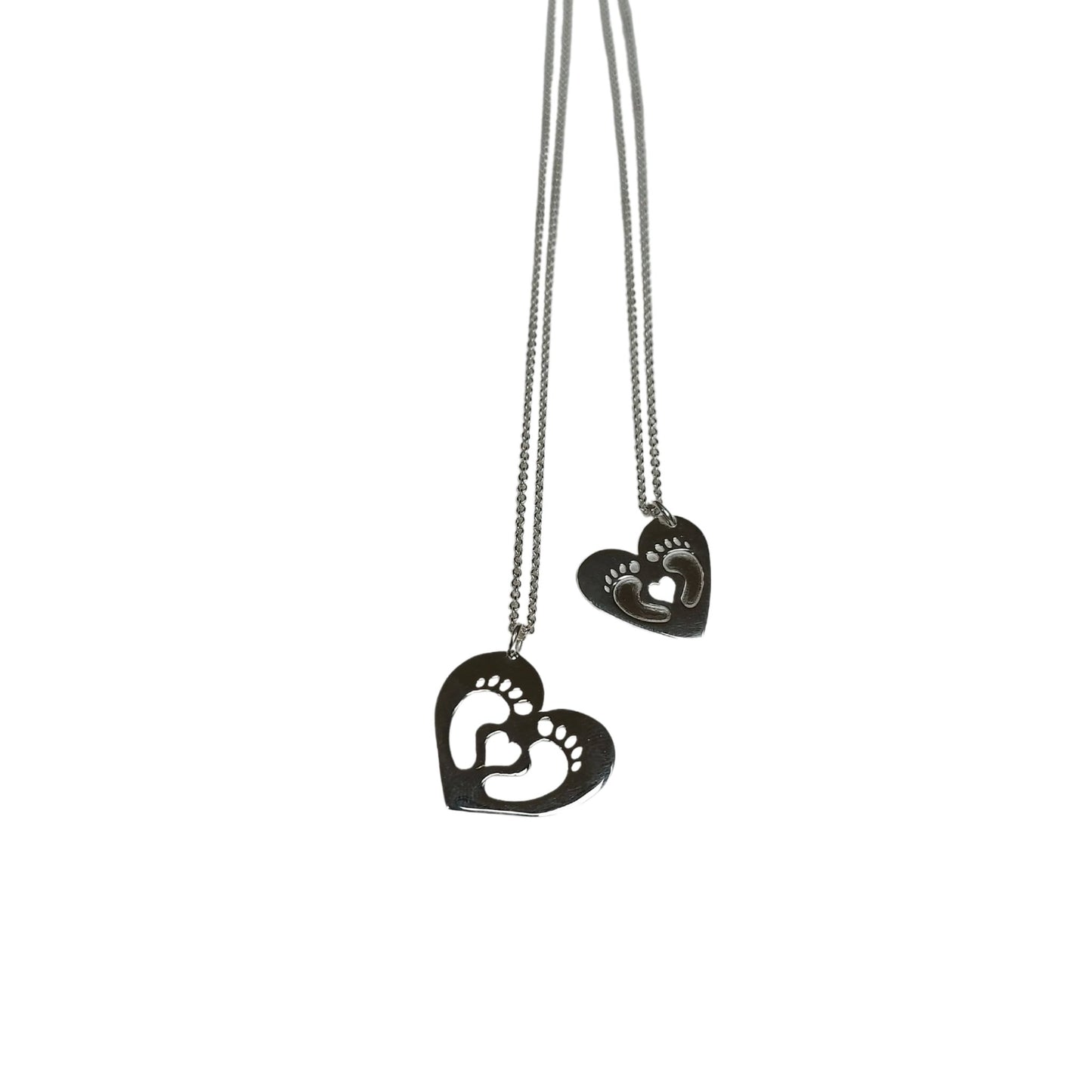 Two clubfoot inspired heart necklaces. One with little feet cut outs, the other with feet embossed around small heart