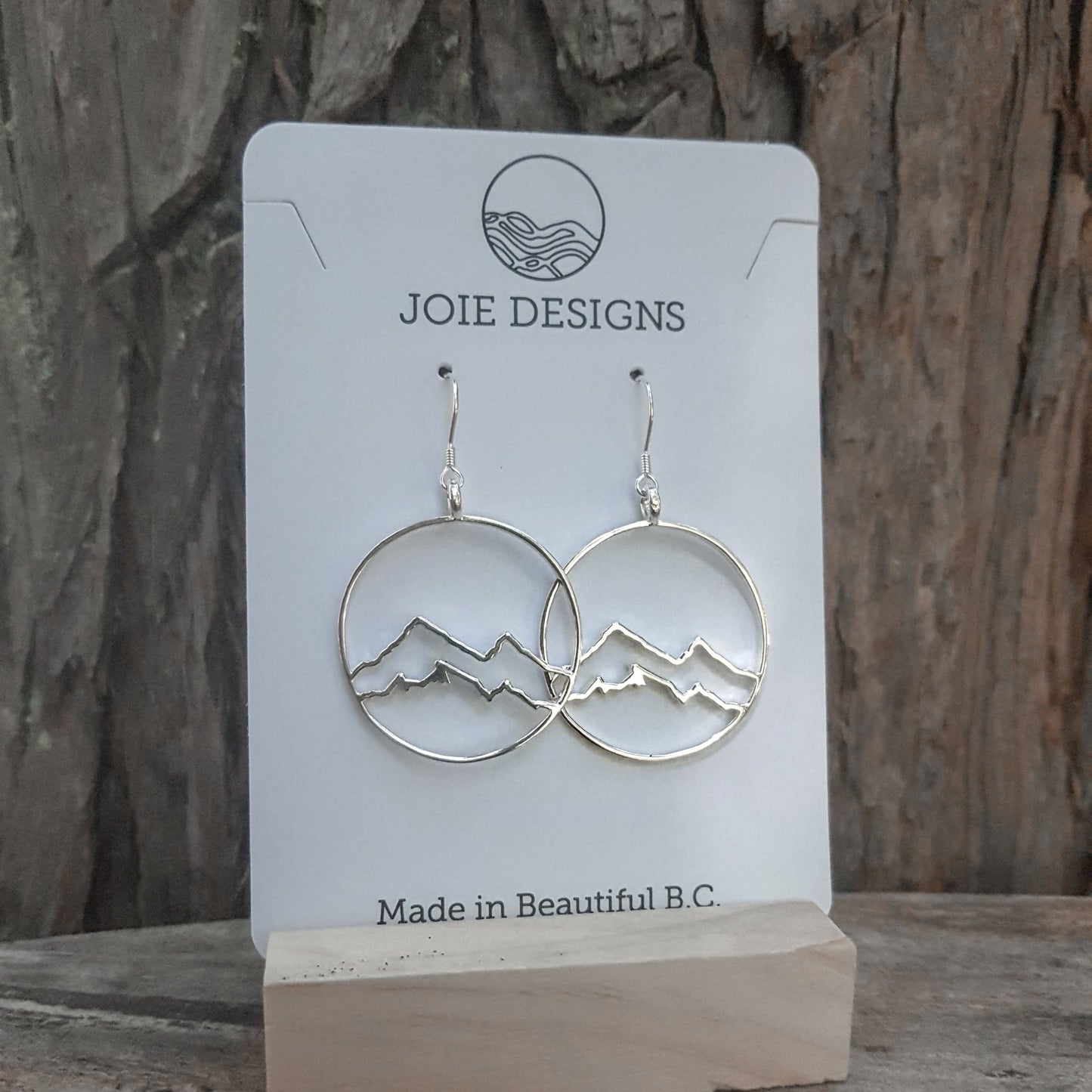 925 sterling silver coastal mountain in circle design hook earring showcased on a jewellery card with wooden background