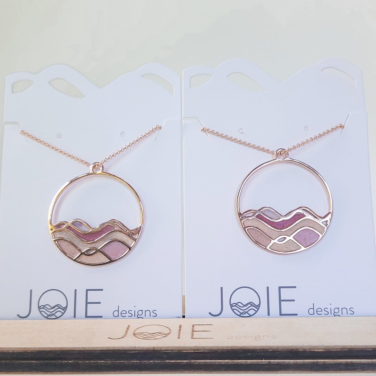 side by side of two sunset colours on ocean waves rose gold pinks and golds circle necklaces