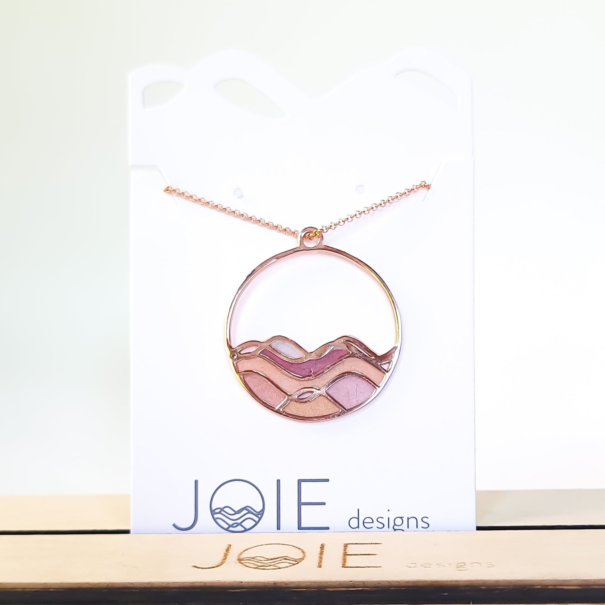 sunset colours on ocean waves rose gold pinks and golds circle necklace close up