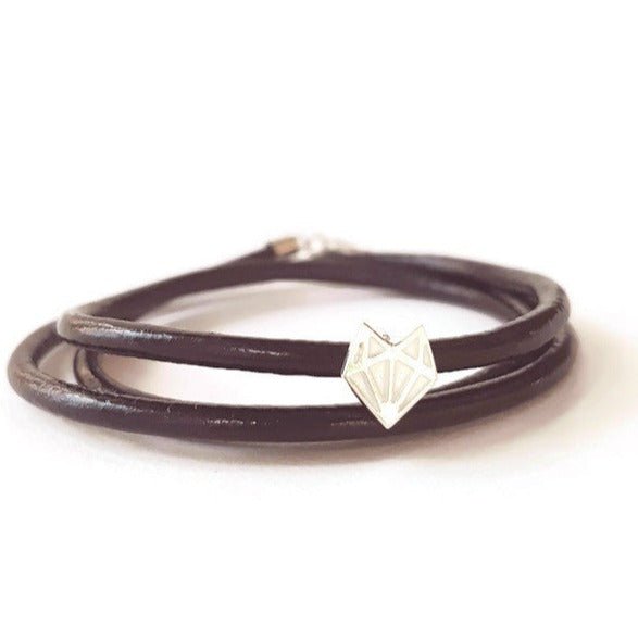 sterling silver geometric fox head charm on black leather wrap bracelet with white background