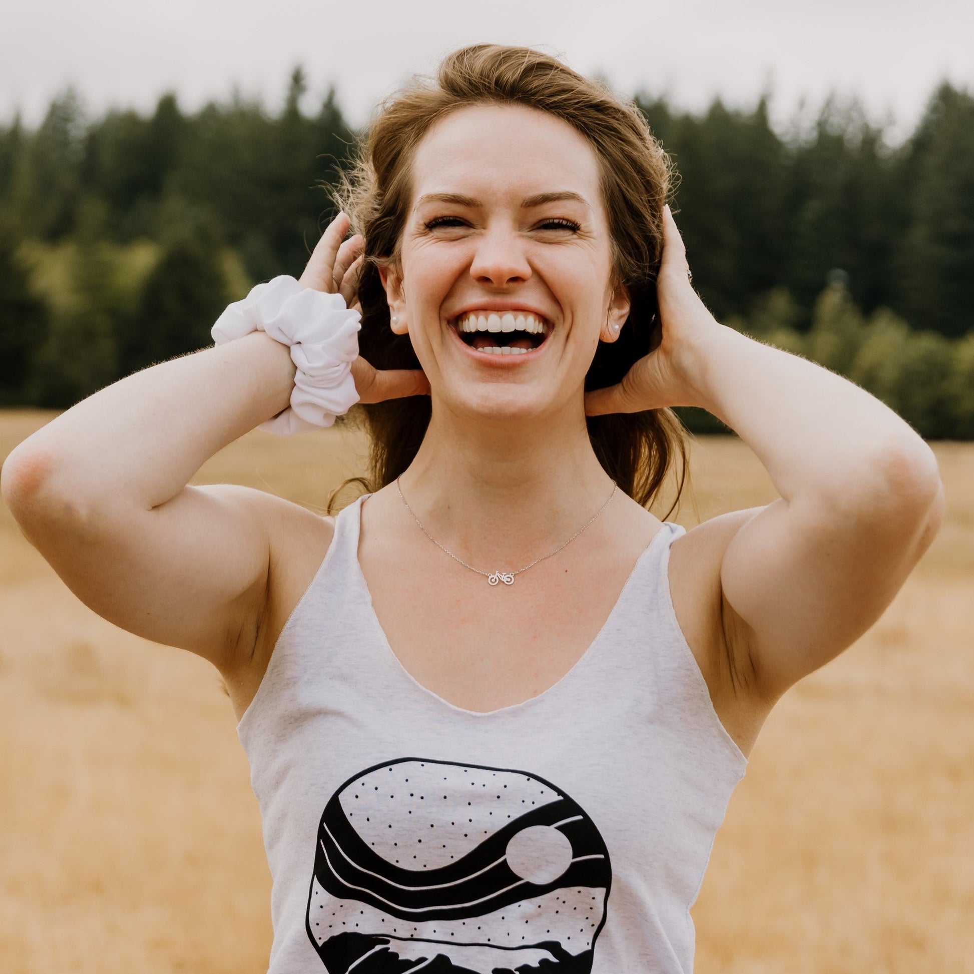 happy woman outside wearing silver fuel for the soul adjustable bike necklace