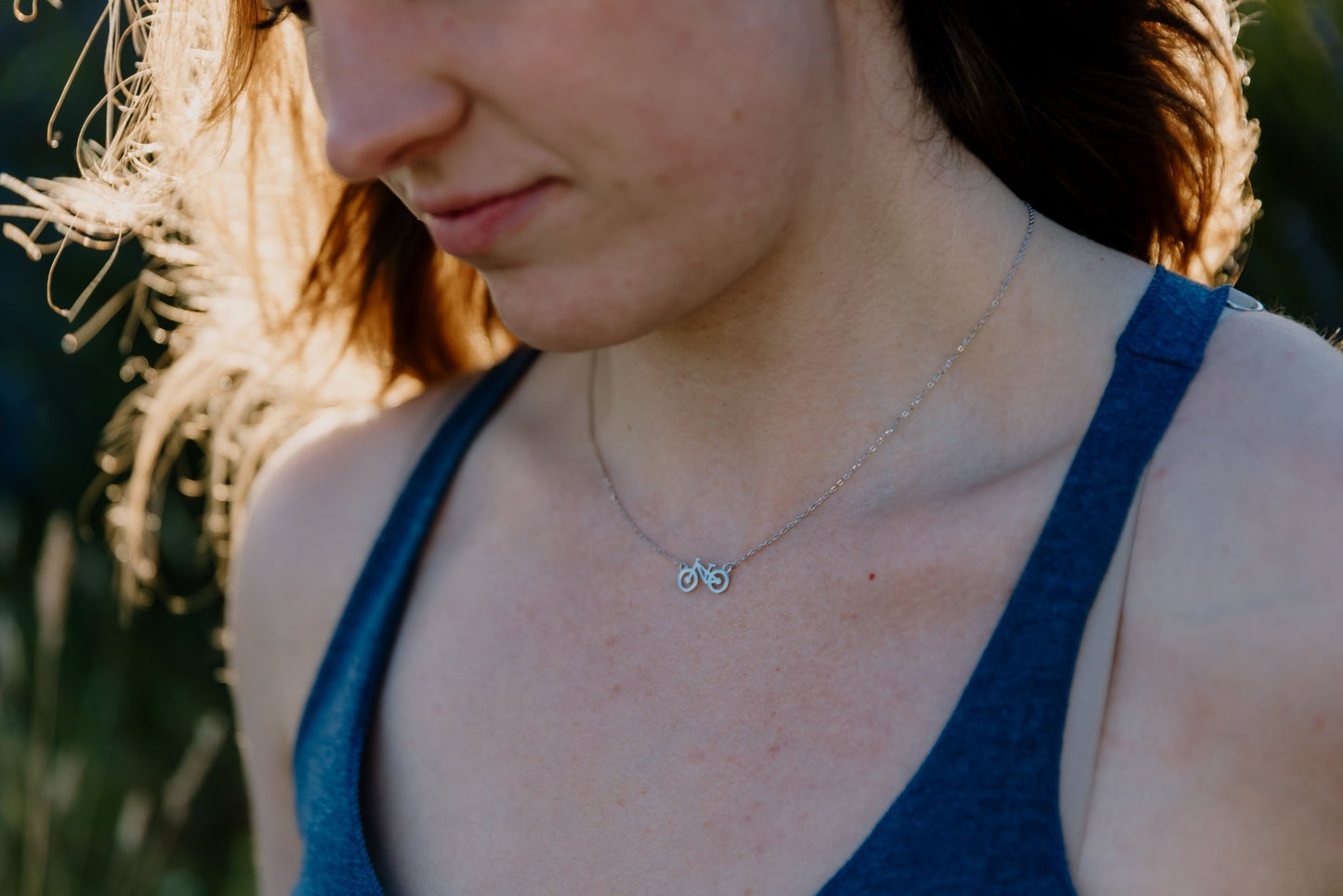 close up of model wearing silver fuel for the soul adjustable bike necklace