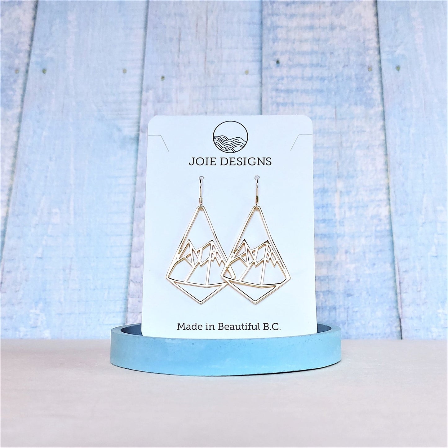 18k yellow gold geometric dangle earrings with mountain design on french ear wires showcased on a jewellery card