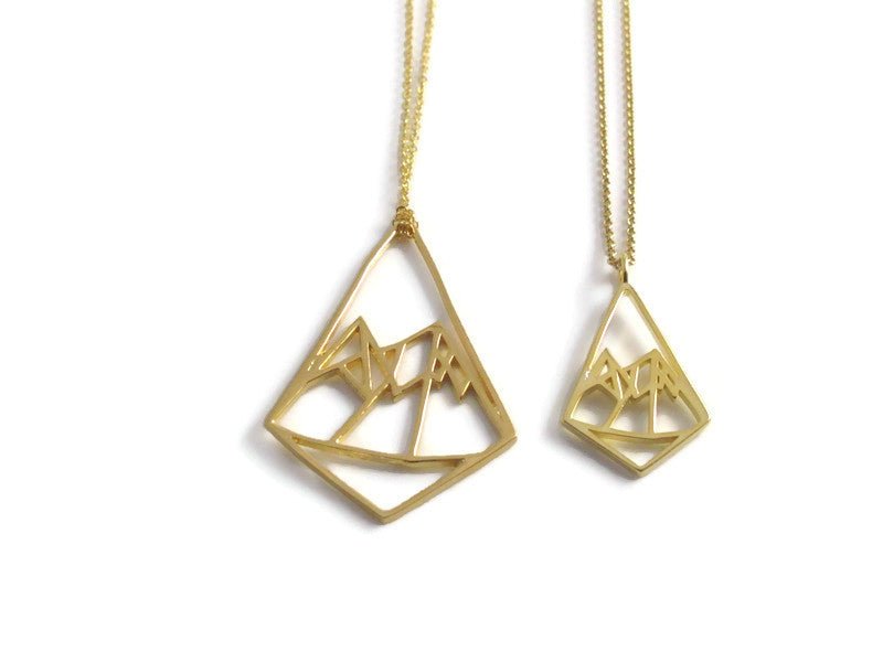 Gold Geo mountain and Petite Geo Mountain pendant necklaces on a white background