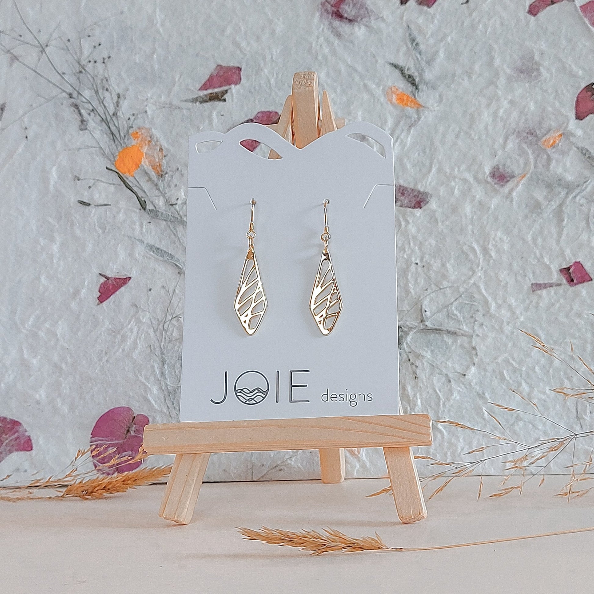 18k plated gold diamond shaped sweet grass earrings on white jewelry card with wildflowers paper background_2
